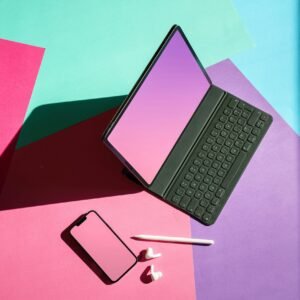 Vibrant flat lay featuring a tablet, smartphone, and stylus on a colorful background.